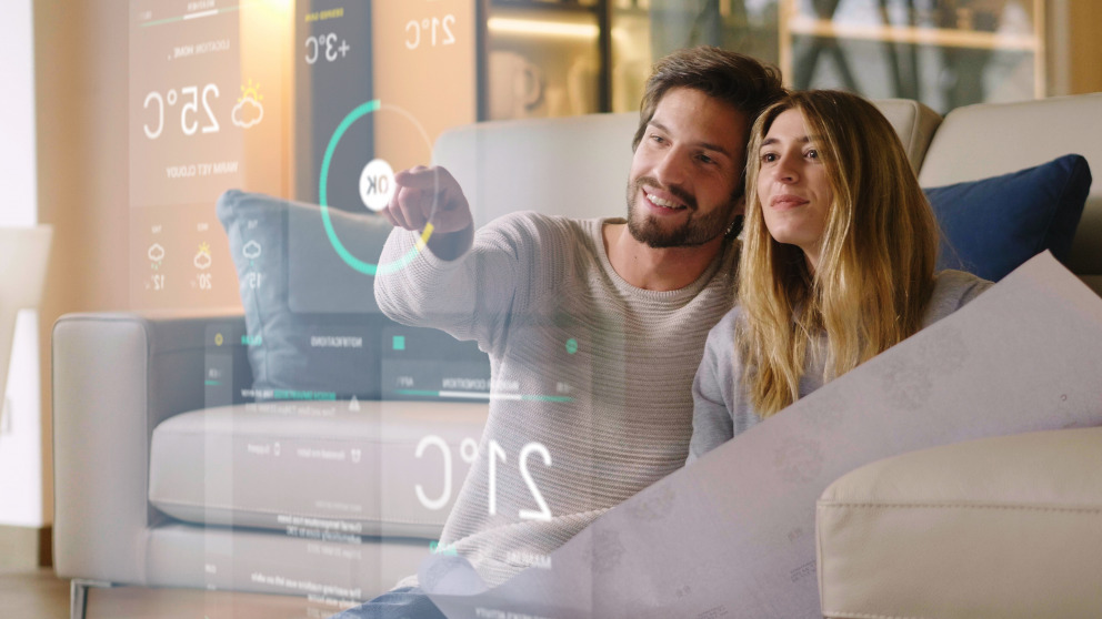 A couple monitors the efficiency of its home heating system from the couch. Shutterstock/ HQuality