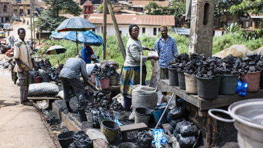 Auf einem Markt in der kamerunischen Hauptstadt Yaoundé verkaufen Händler Kohle, die unter anderem für Kochherde genutzt wird. Viele Entwicklungsländer haben nur wenig Zugang zu Energiewende-Zukunftstechnologien. 