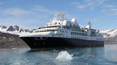 Ein Kreuzfahrtschiff fährt am Monacobreen-Gletscher in Svalbard, Hohe Arktis, entlang.  Die neue Zugänglichkeit der Arktis und damit verbundene Nutzungsmöglichkeiten wie Schifffahrt und Tourismus bringen neue Gefahren mit sich.
